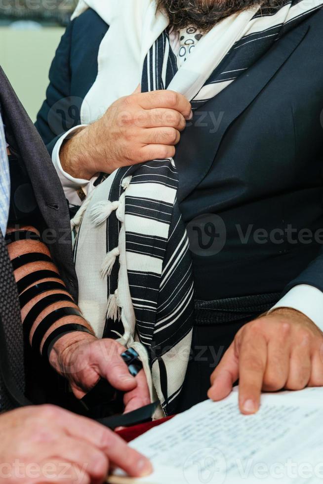 Hand of boy reading the Jewish Torah at Bar Mitzvah photo