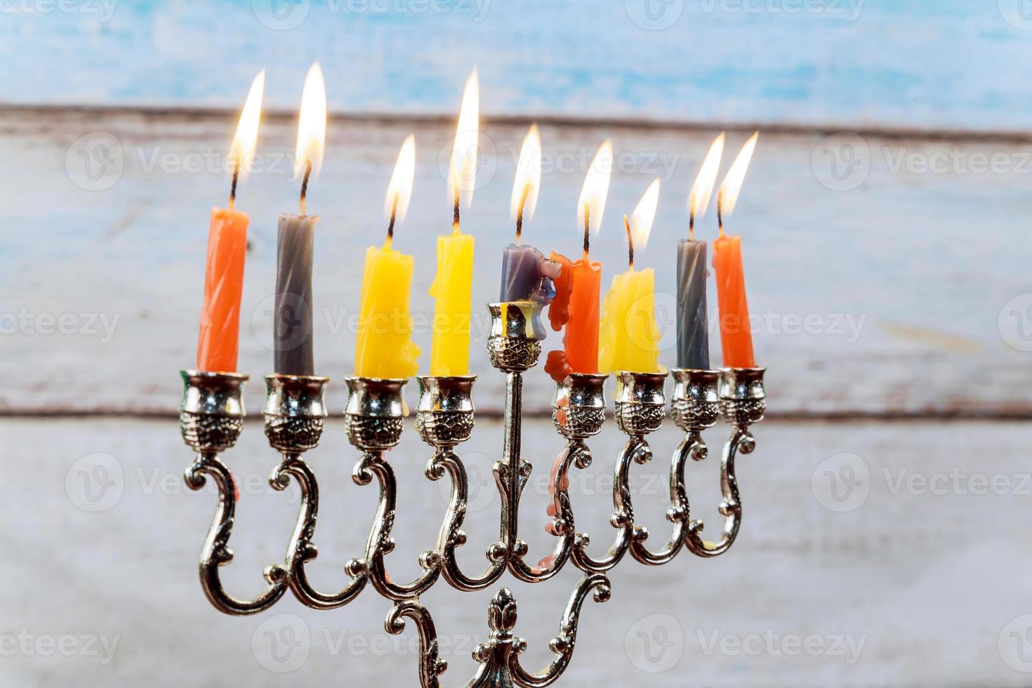 Hanukkah menorah with candles and silver dreidel. photo