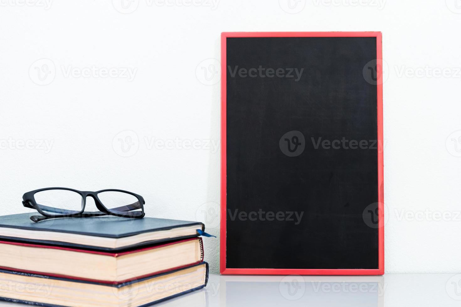 Chalkboard mock up frame and old books with eyeglasses photo