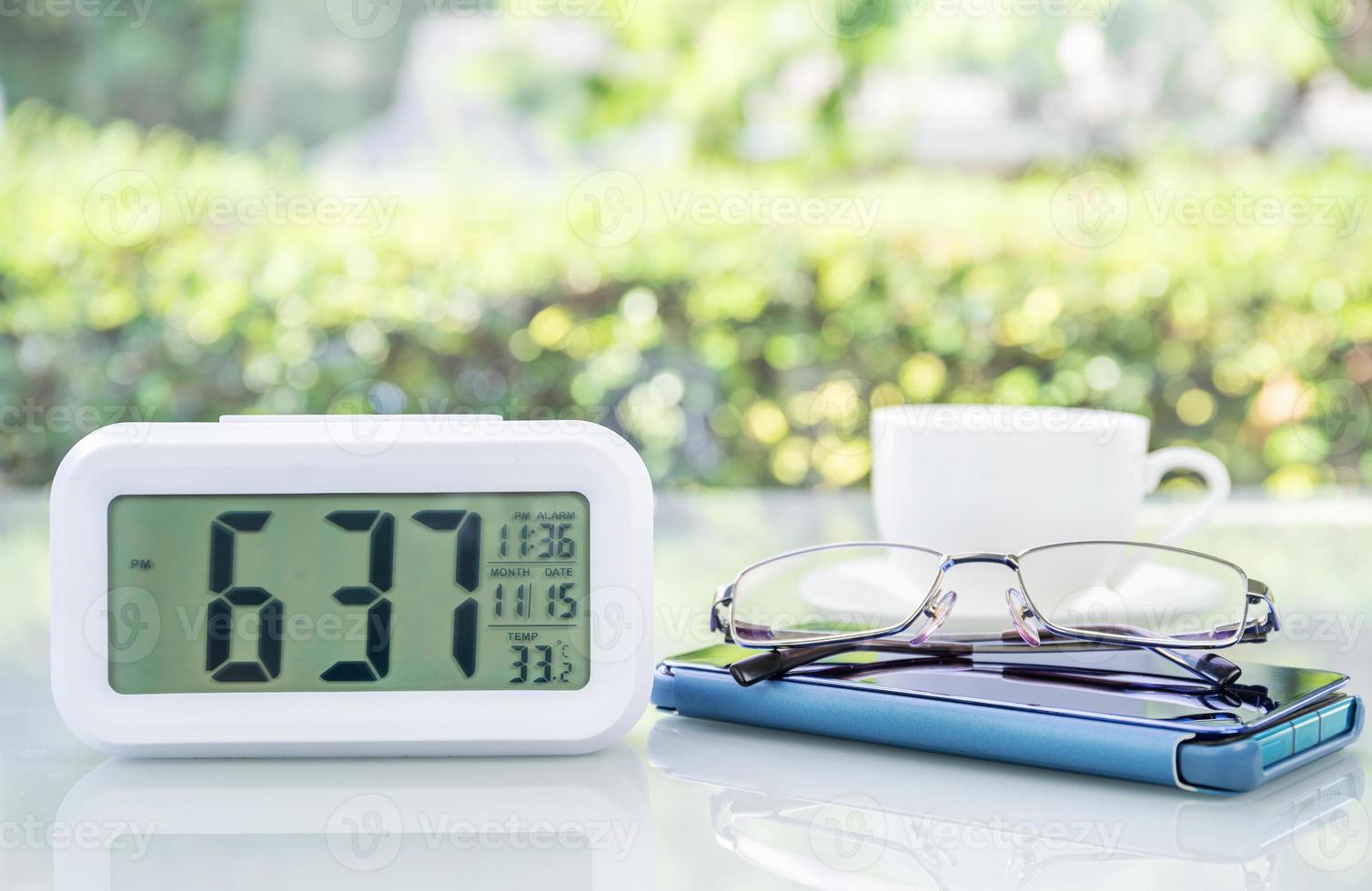 reloj digital y anteojos con taza de café foto