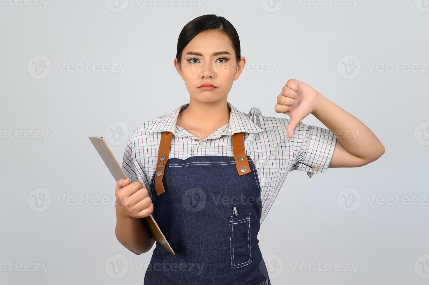 Portrait of young asian woman in waitress uniform pose with clipboard photo