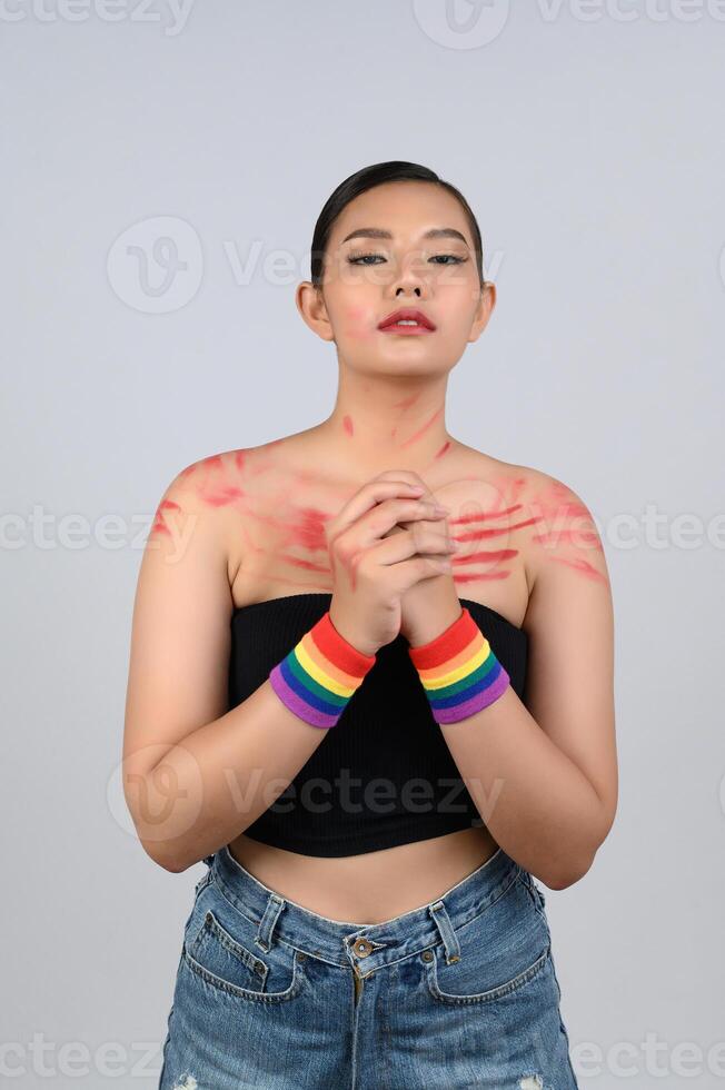 Portrait young asian woman in concept LGBQ with wristband on white background photo