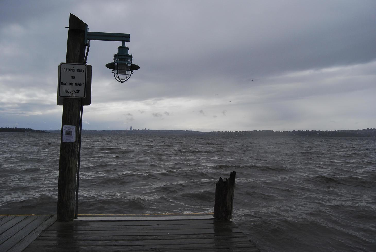 Light post on the end of dock under clouds photo