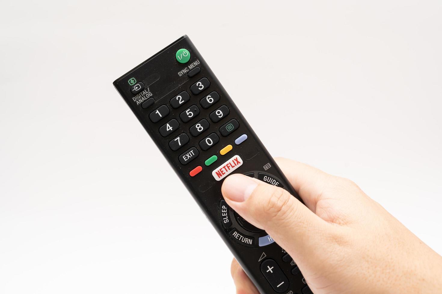 Samutprakarn Thailand Jan 23 2023 A Smart TV remote commander with Smart TV Assistant function like Netflix. Male hand holding television remote Netflix. photo