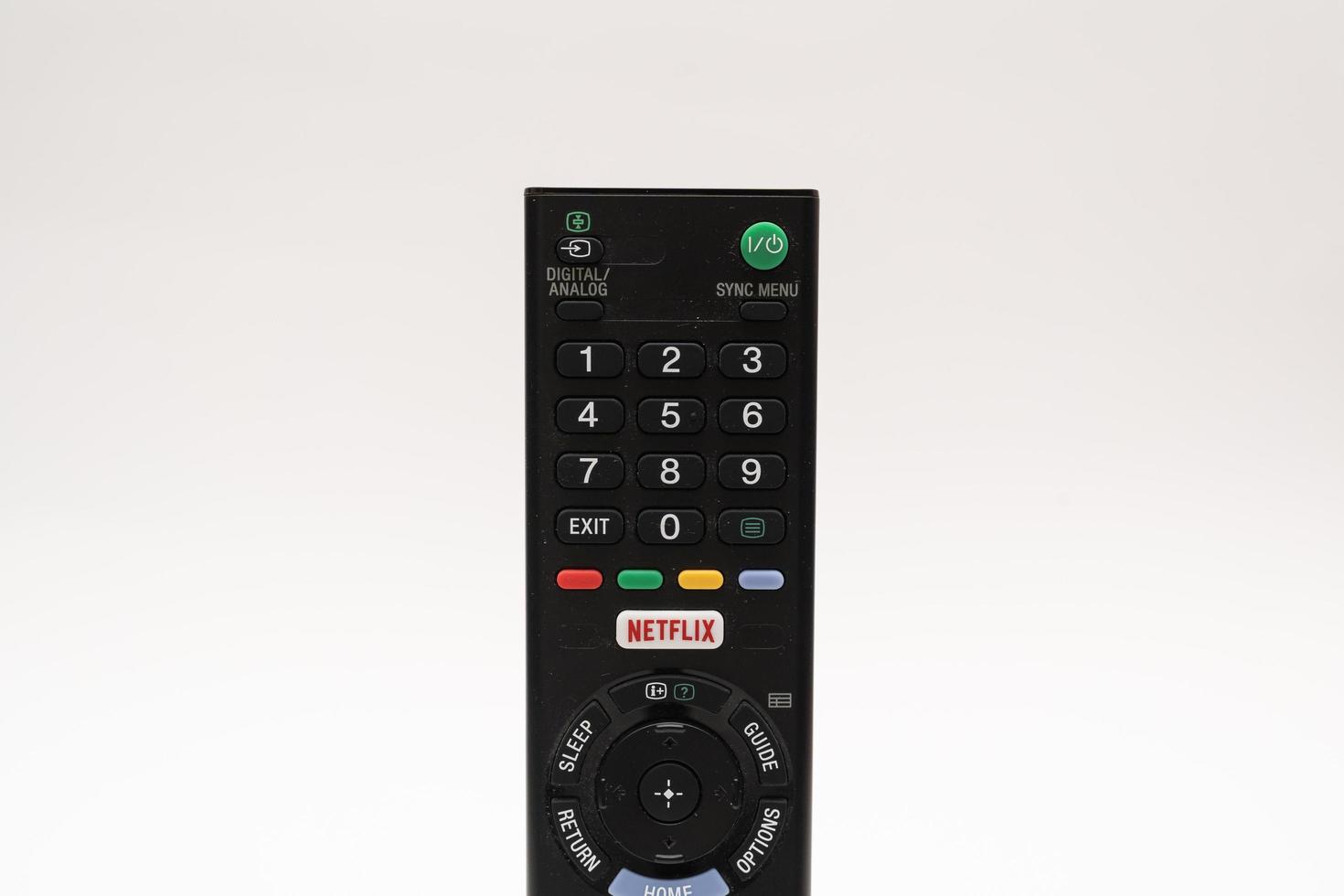 Samutprakarn Thailand Jan 23 2023 A Smart TV remote commander with Smart TV Assistant function like Netflix. Male hand holding television remote Netflix. photo