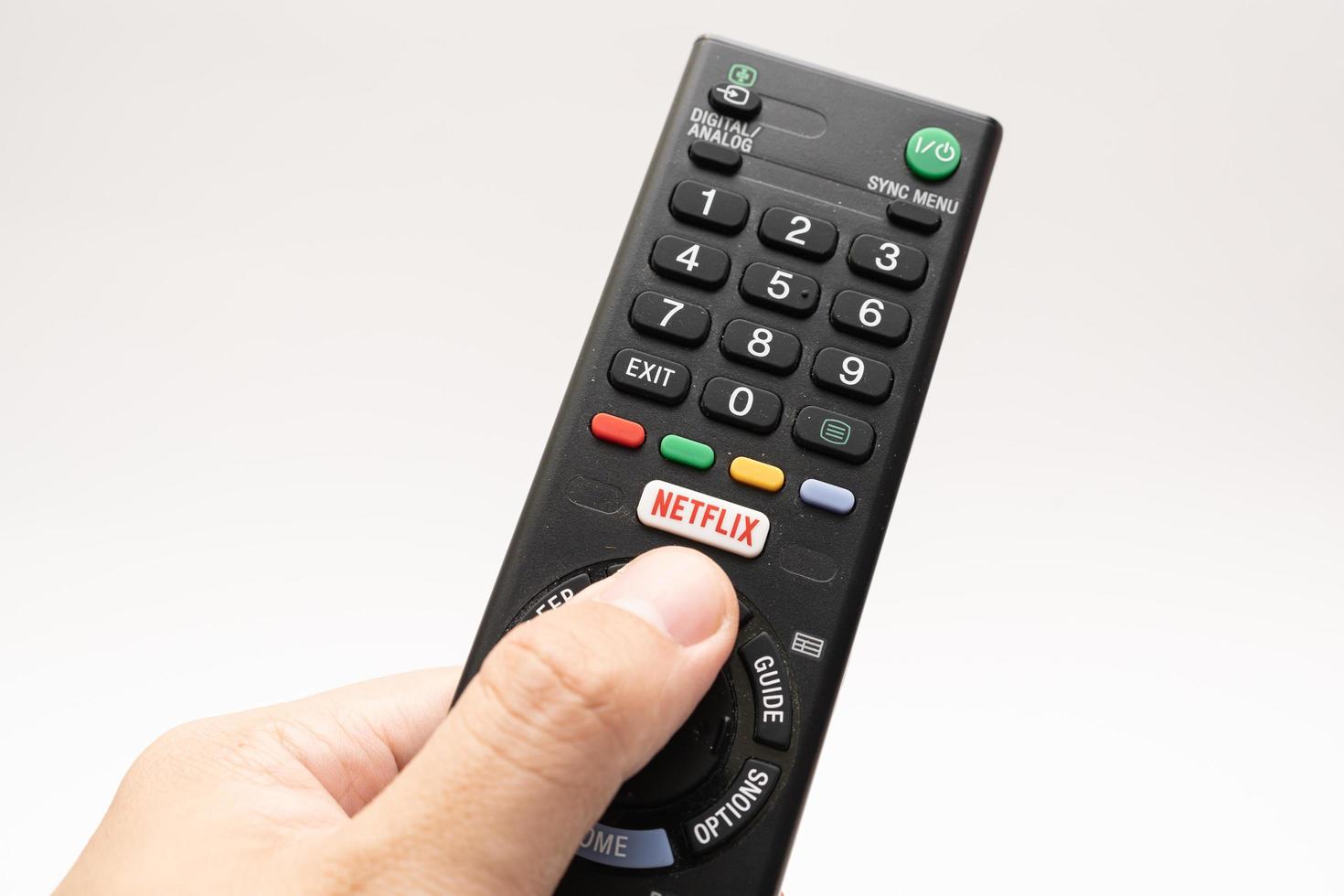 Samutprakarn Thailand Jan 23 2023 A Smart TV remote commander with Smart TV Assistant function like Netflix. Male hand holding television remote Netflix. photo