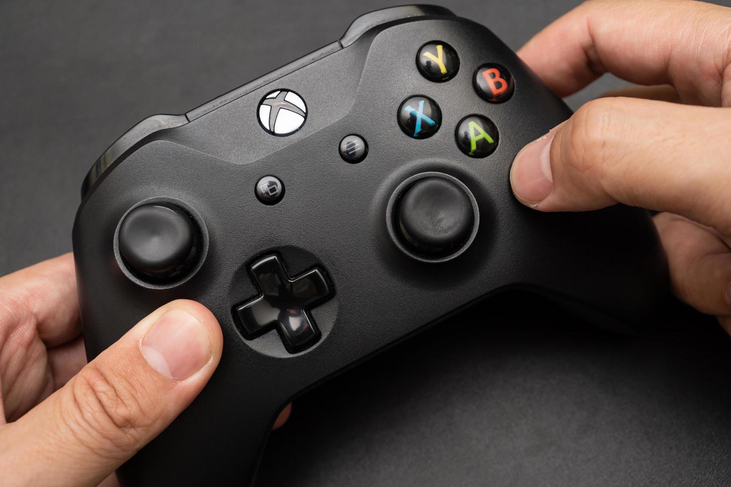 Samutprakarn Thailand Jan 23 2023 Hand holding Wireless gamepad for the Xbox One a home video game console produced by Microsoft. Black Xbox game controller. photo
