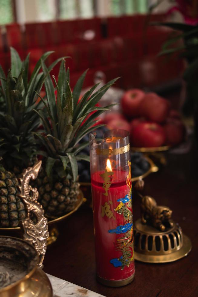 Bandung, Indonesia, 2020 - The offerings like food and candle on the top of the red Buddhist table during the praying from the monks photo