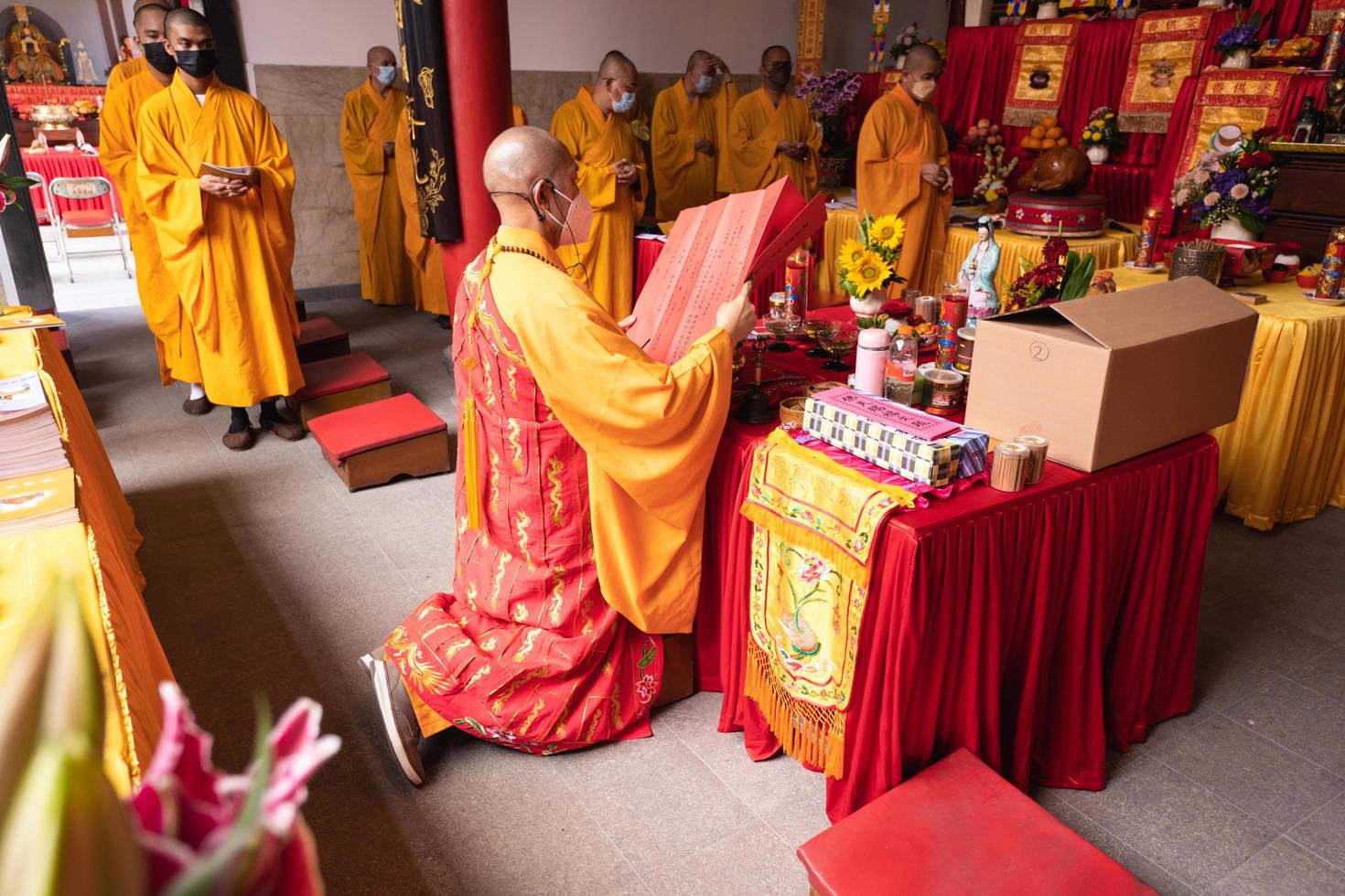 Bandung, Indonesia, 2020 - The Monks with orange clothes pray together in front of the altar photo
