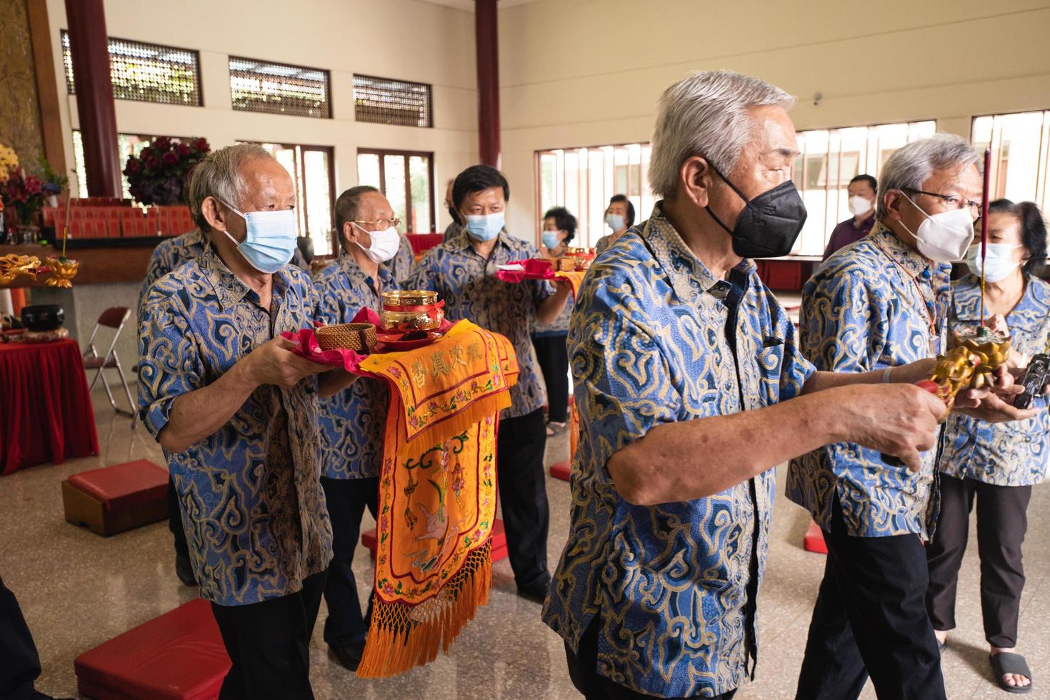 Bandung, Indonesia, 2020 - Buddhist People pray together with the monks while giving the offering in front of the altar photo