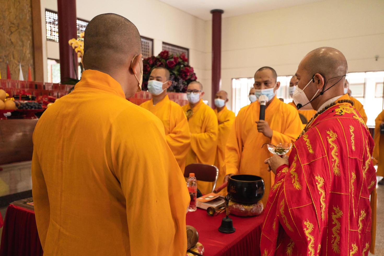Bandung, Indonesia, 2020 - The Monks with orange clothes pray together in front of the altar photo