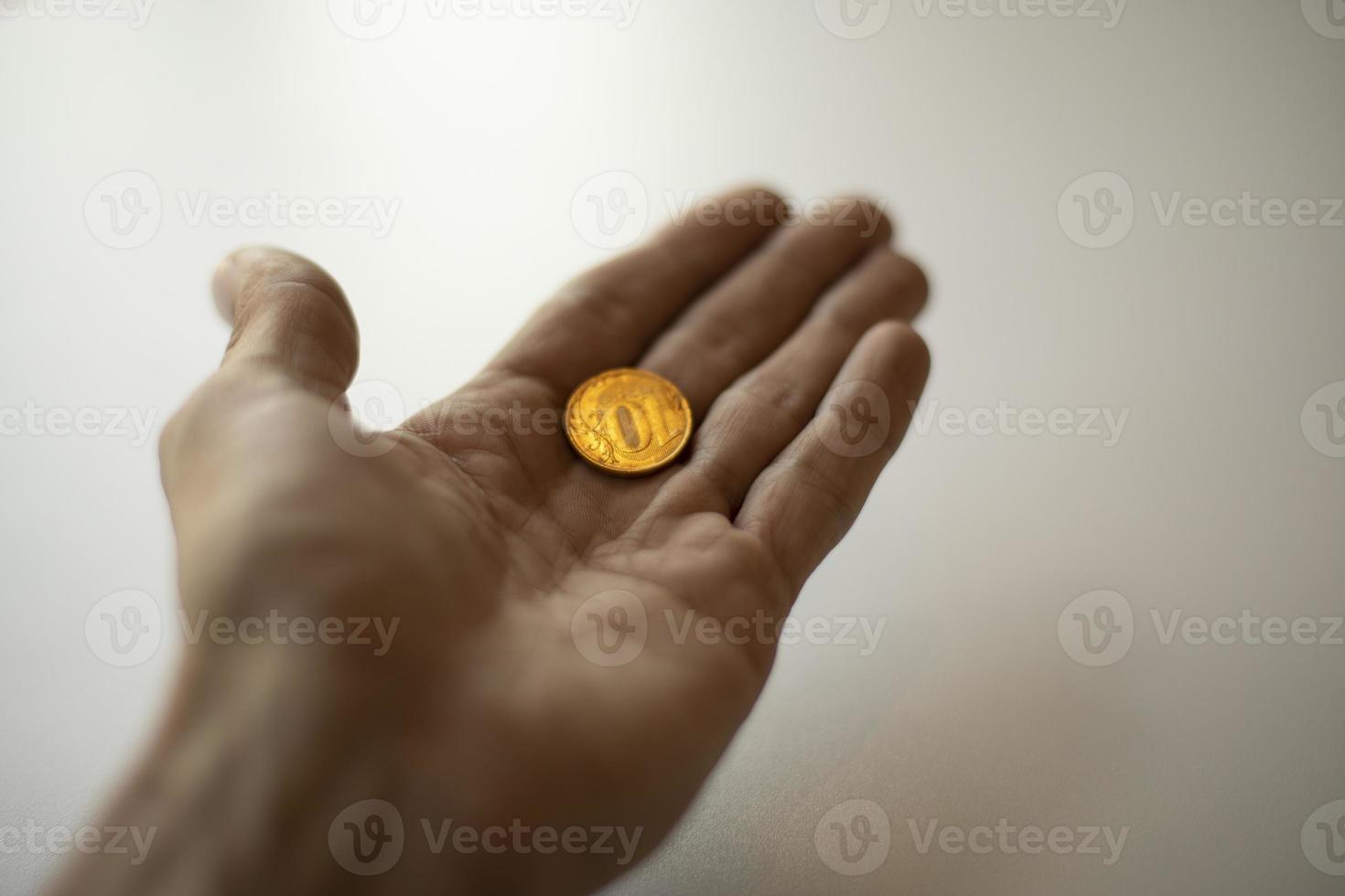 Russian money in hand. Ten rubles in palm of your hand. Gold coin. photo