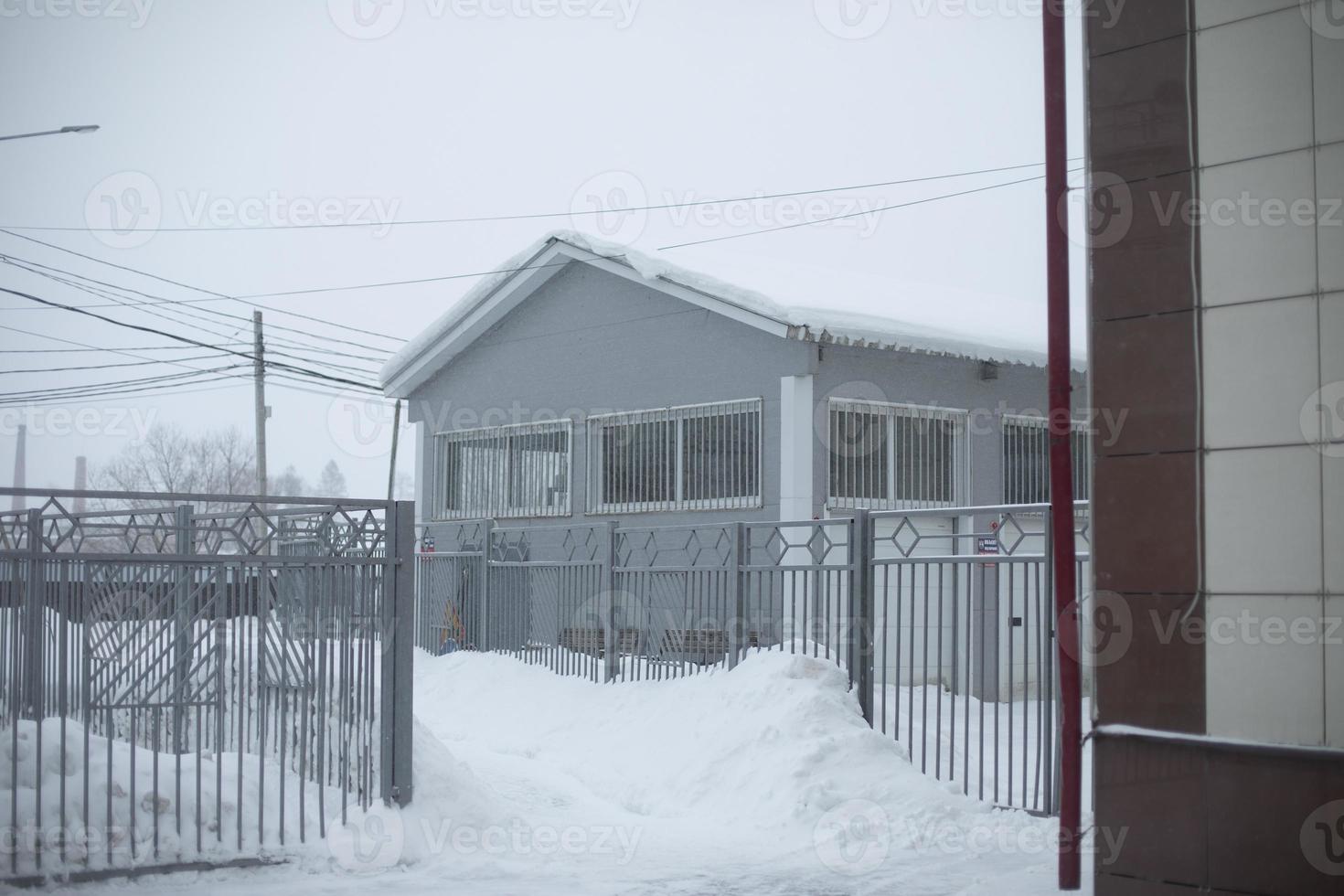 edificio es en invierno. almacén de una planta en un día frío. nieve afuera. ventisqueros en la ciudad después de la tormenta de nieve. foto