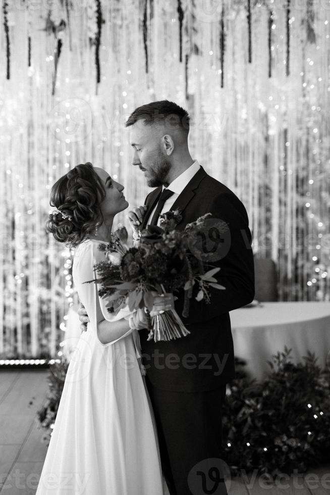 retrato de una joven pareja de recién casados en looks de boda foto