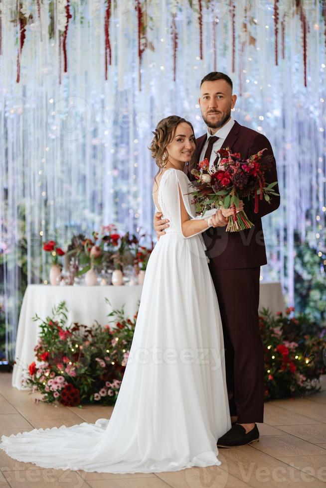 retrato de una joven pareja de recién casados en looks de boda foto