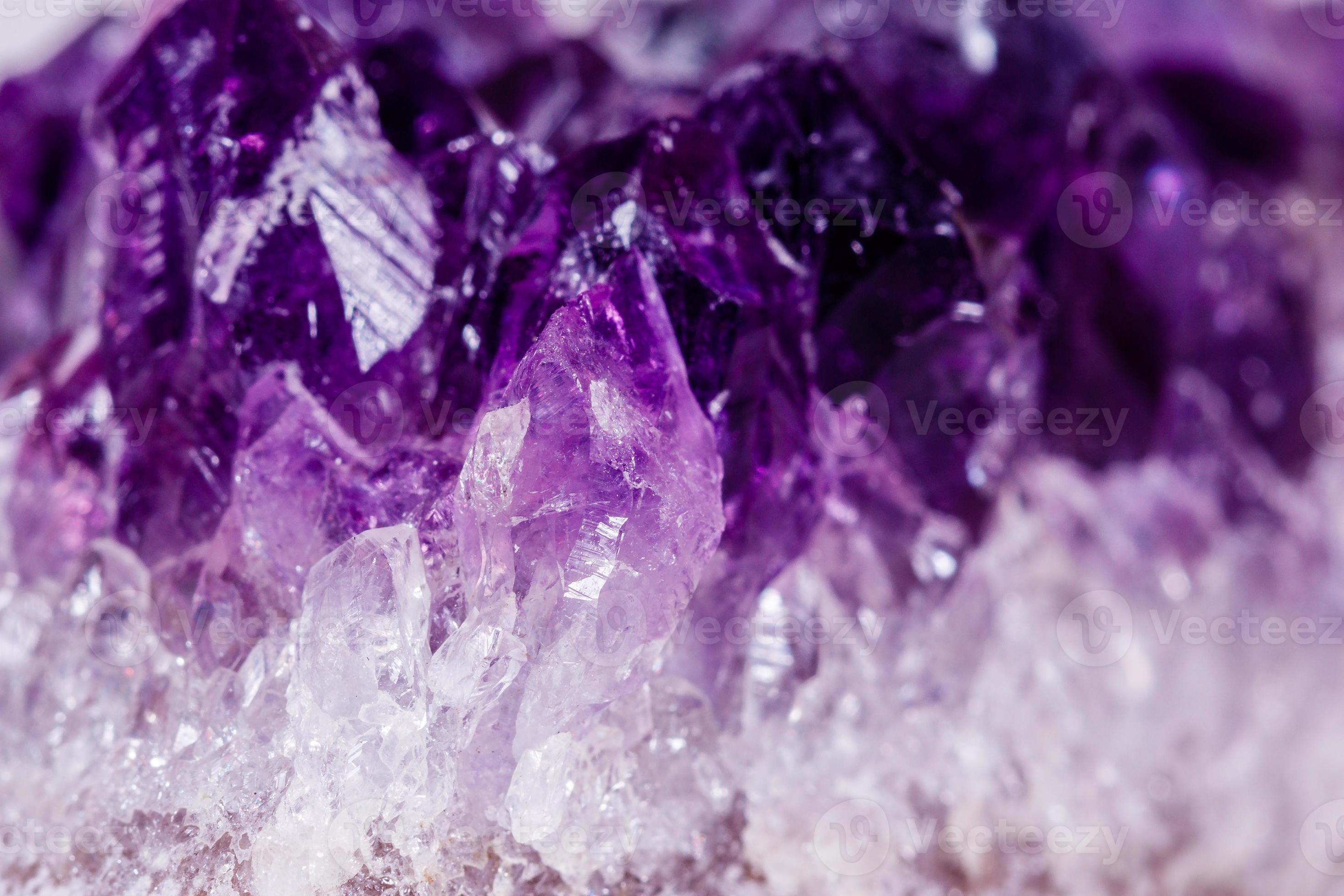 Macro mineral stone purple amethyst in crystals on a white background