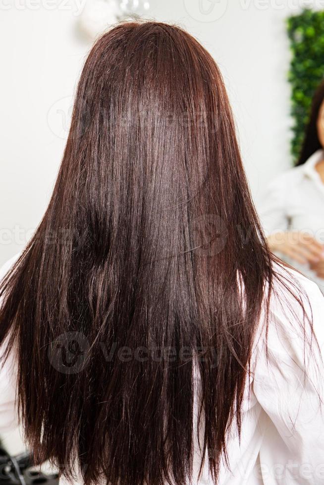 hermosa mujer joven con cabello largo y negro en un salón de belleza. foto