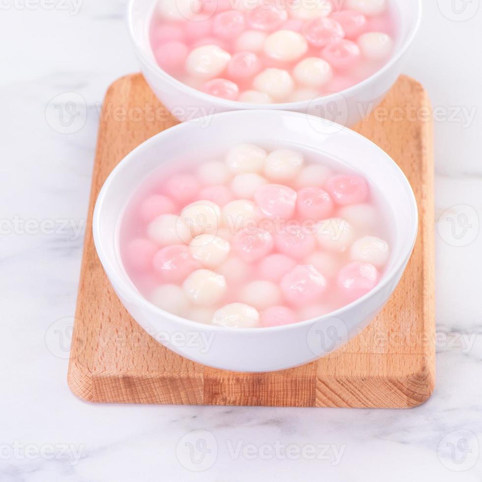 Tang yuan, tangyuan, delicious red and white rice dumpling balls in a small bowl. Asian traditional festive food for Chinese Winter Solstice Festival, close up. photo
