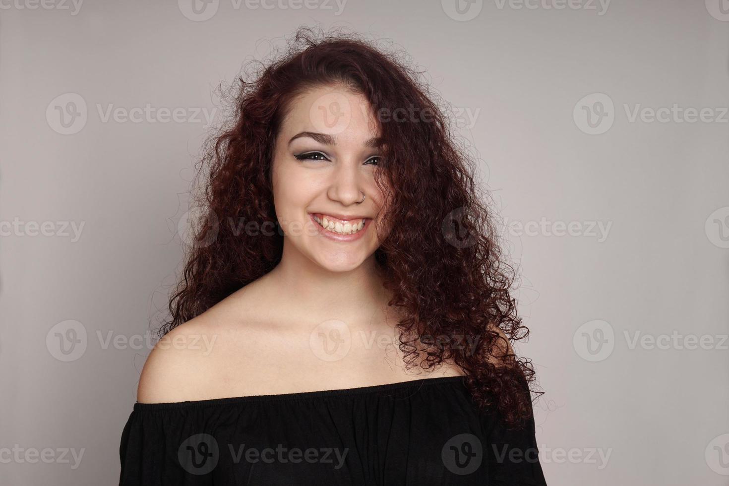 adolescente sonriente con el pelo rizado foto