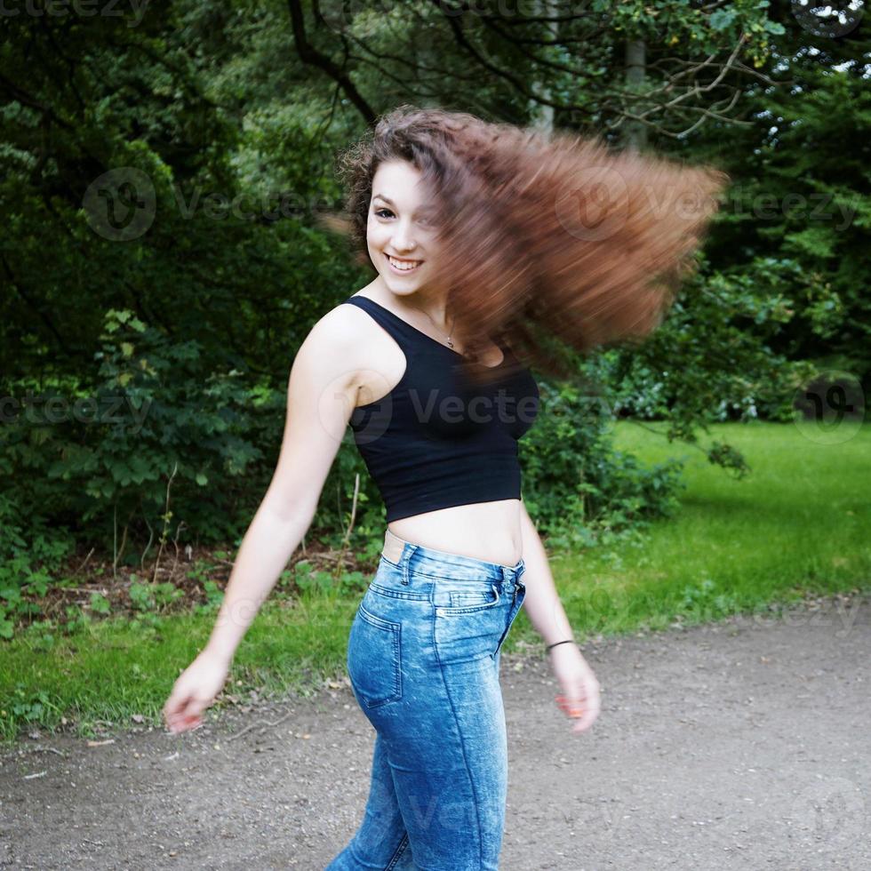 playful young woman swinging her hair photo