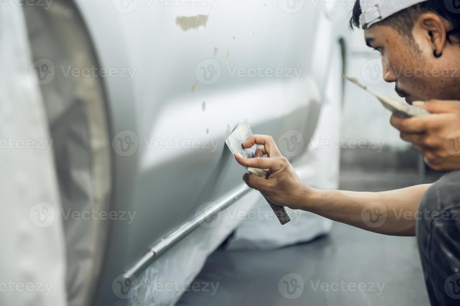 un pintor experto que detalla una imprimación profesional de pintura de automóviles mientras pule un automóvil blanco brillante, detalles de automóviles, lavado de automóviles y reparación de pintura. imagen recortada enfoque selectivo foto