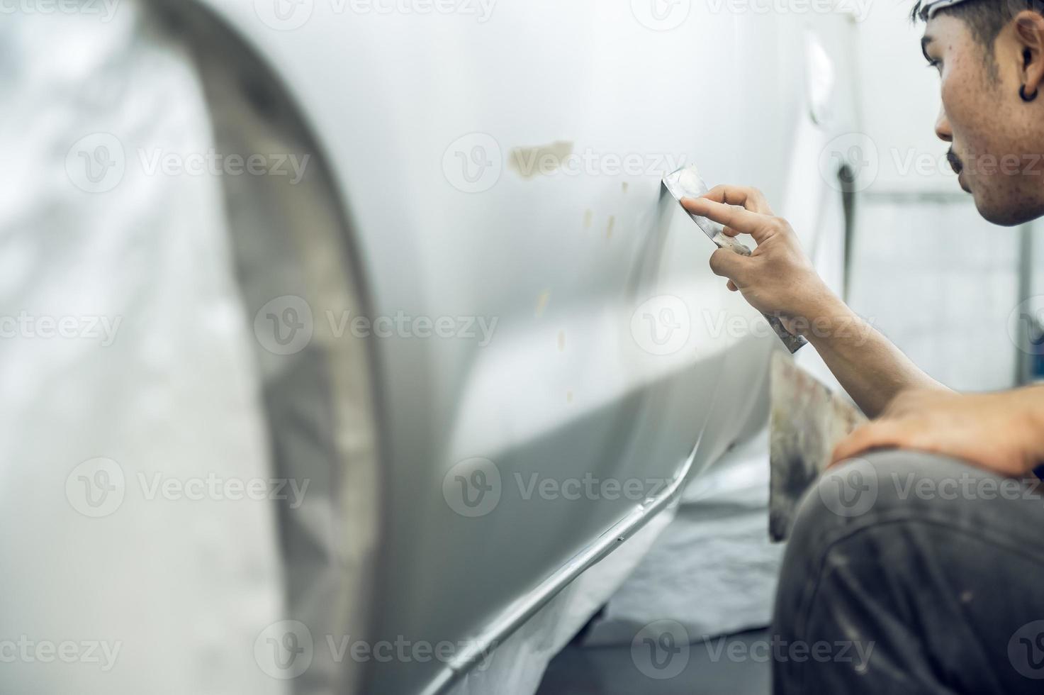 un pintor experto que detalla una imprimación profesional de pintura de automóviles mientras pule un automóvil blanco brillante, detalles de automóviles, lavado de automóviles y reparación de pintura. imagen recortada enfoque selectivo foto
