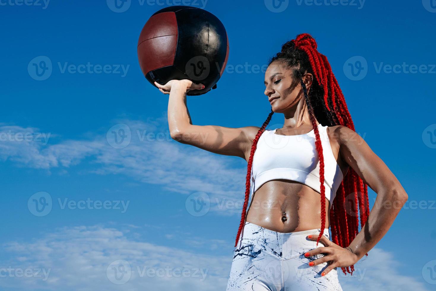 background sky. Athletic woman with med ball. Strength and motivation.Photo of sporty  woman in fashionable sportswear photo