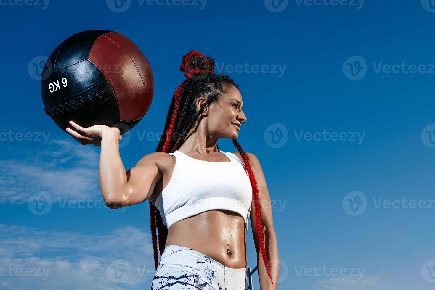 background sky. Athletic woman with med ball. Strength and motivation.Photo of sporty  woman in fashionable sportswear photo