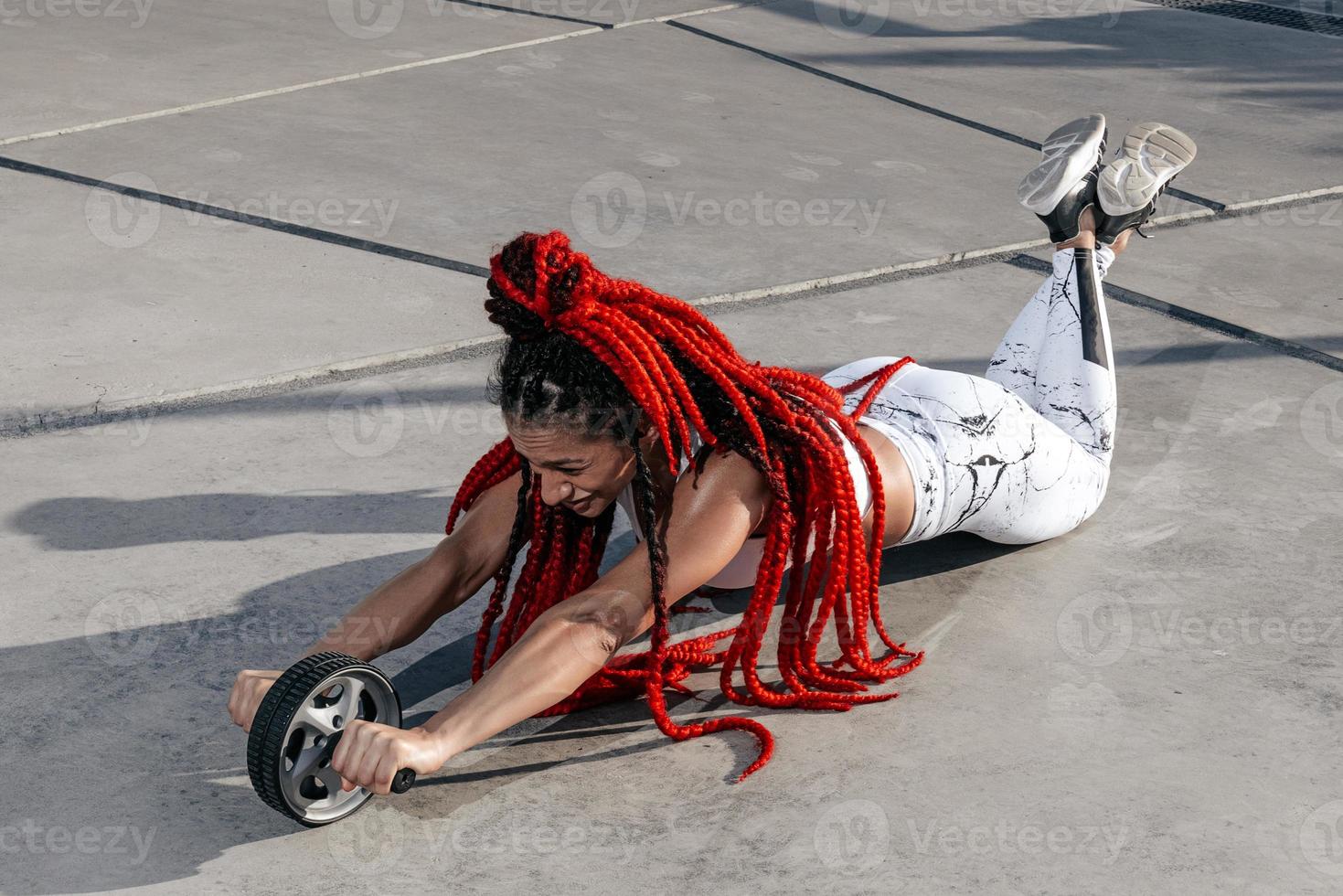 Athletic woman doing exercise exercise with a roller. Strength and motivation.Photo of sporty  woman in fashionable sportswear photo