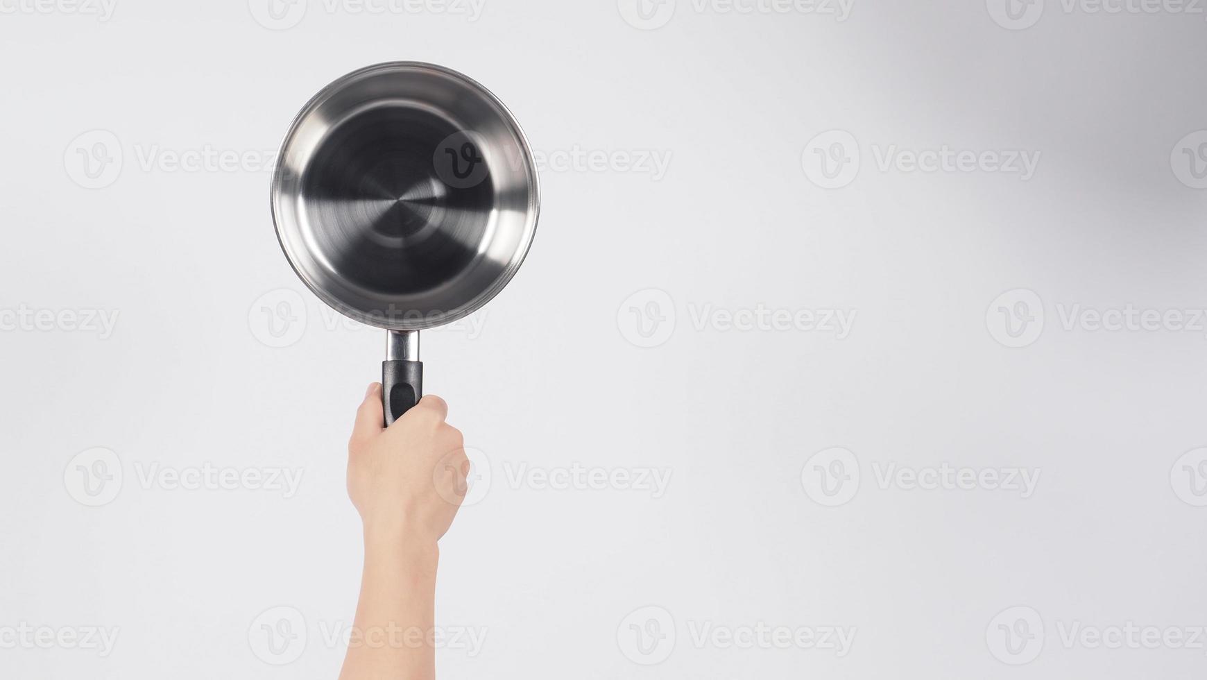 Pot cleaning Man hand on white background cleaning the non stick pot with handy dish washing sponge which yellow color on the soft side and green on hard side for hygiene after cook. Electric pot photo