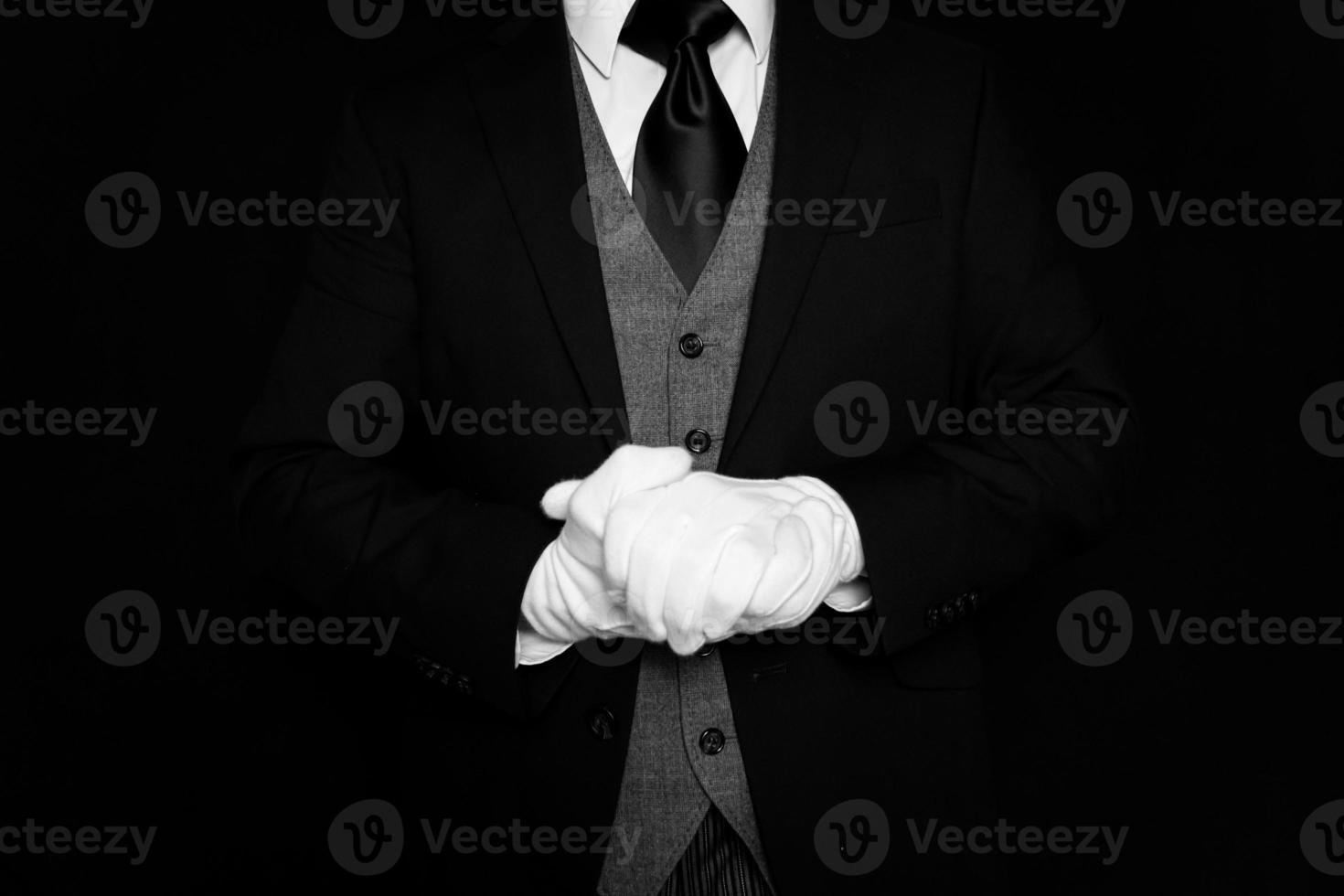 retrato de mayordomo con traje oscuro y guantes blancos ansiosos por servir. concepto de industria de servicios y hospitalidad profesional. foto
