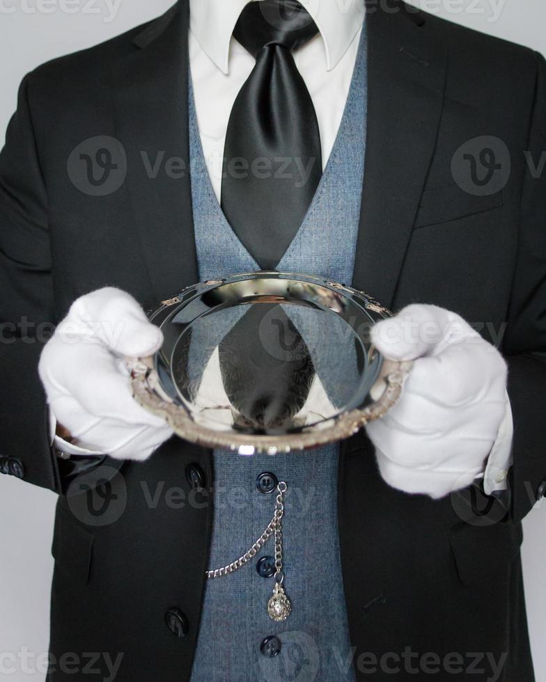 Portrait of Butler or Waiter Holding Silver Serving Tray on White Background. Concept of Service Industry and Professional Courtesy photo