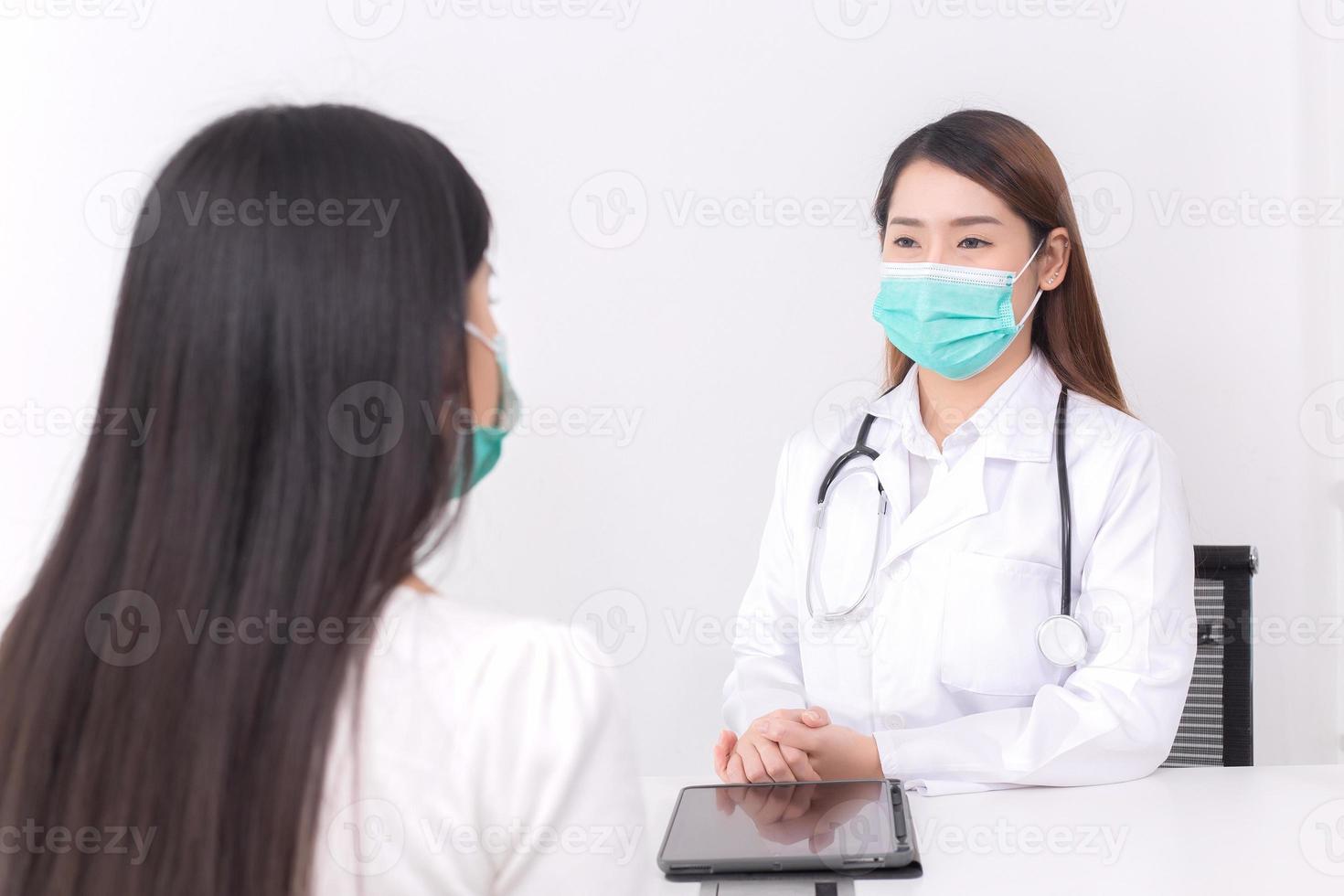 Asian woman doctor is talking with her patient to consult and check symptom which wears medical face mask always diagnostic in new normal and health care concept. photo