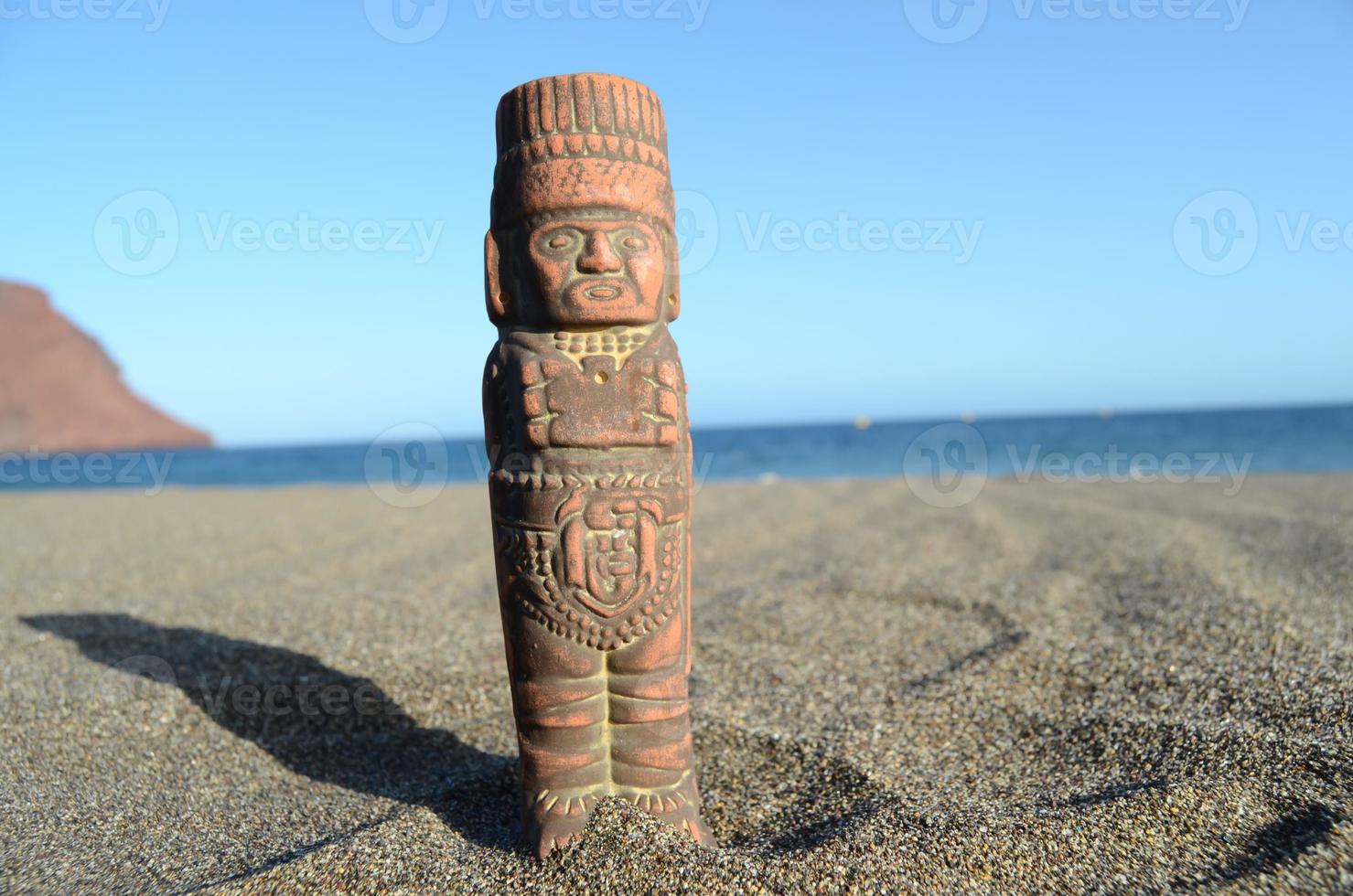 Small Mesoamerican statue at the beach photo