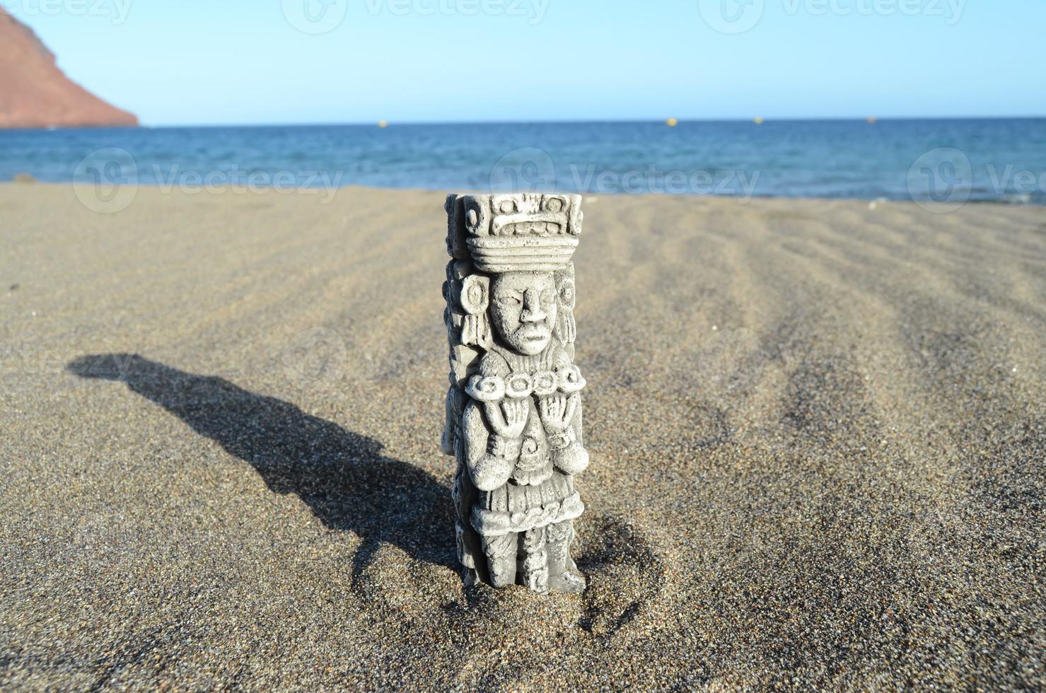 Small Mesoamerican statue at the beach photo