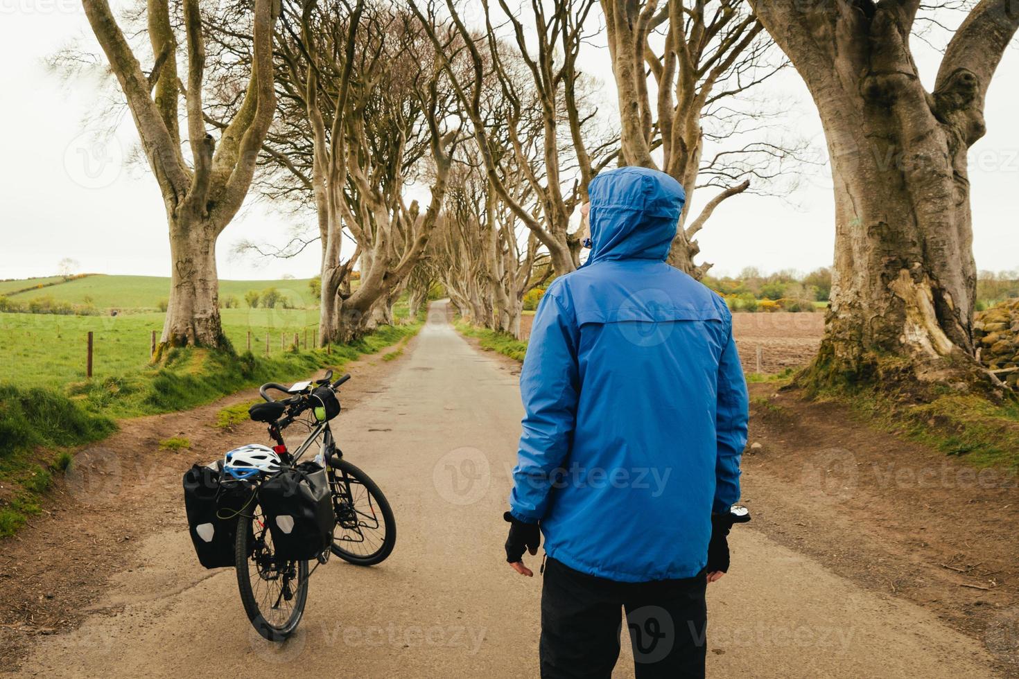 Touring bicycle set up with panniers. dark hedges in Northern Ireland. Traveler male stand by bicycle visit famous landmarks in Northern Ireland photo