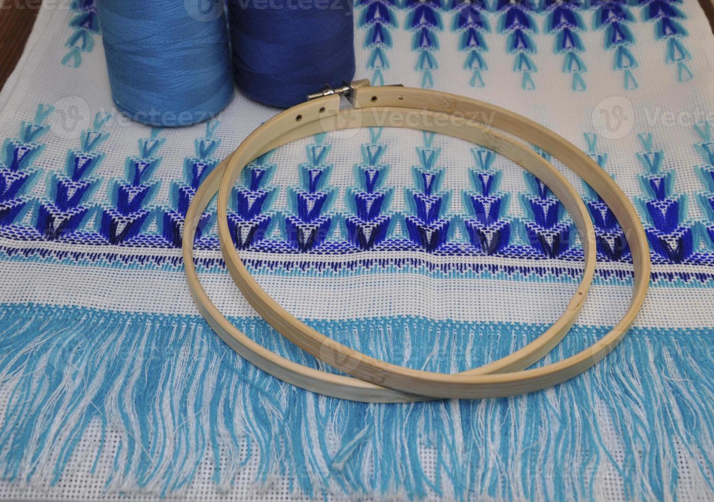 Wooden hoop for embroidery on a table with a thread photo