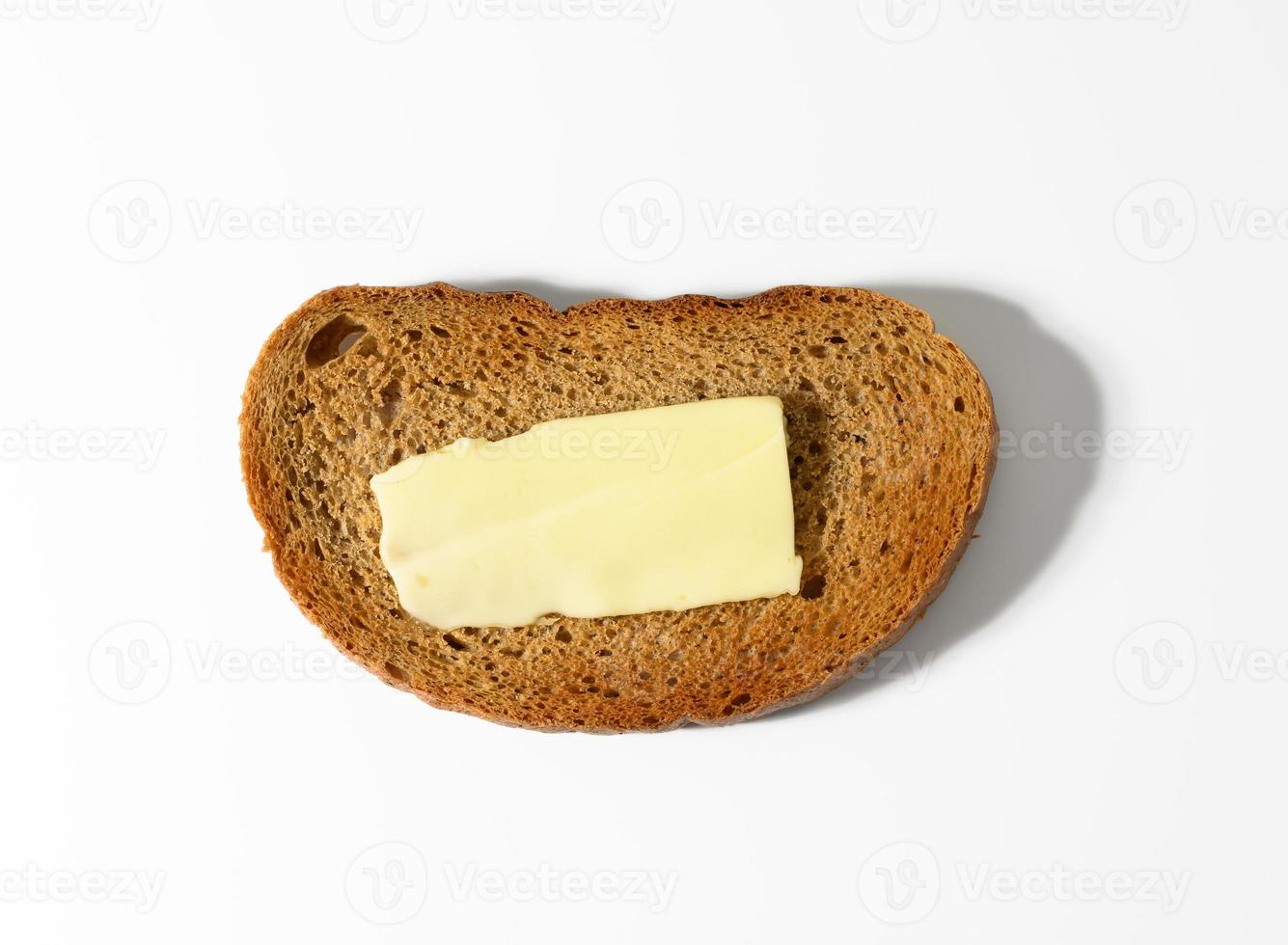 oval slice of rye flour bread, a slice of butter on top photo