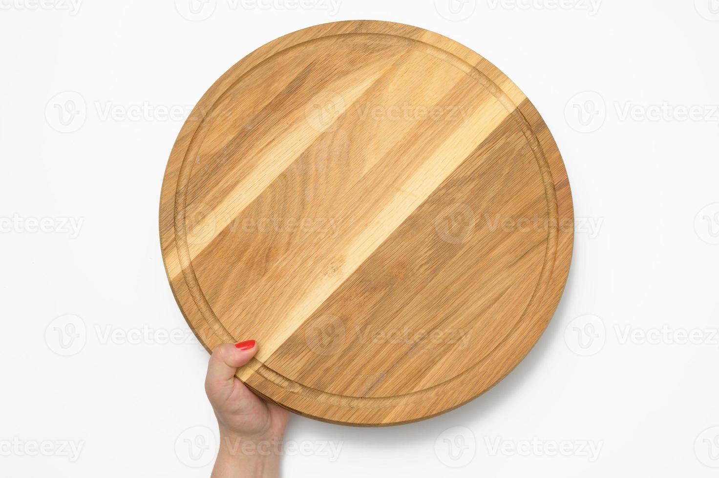 mano de mujer sosteniendo una tabla de pizza de madera redonda vacía en la mano, parte del cuerpo sobre fondo blanco foto