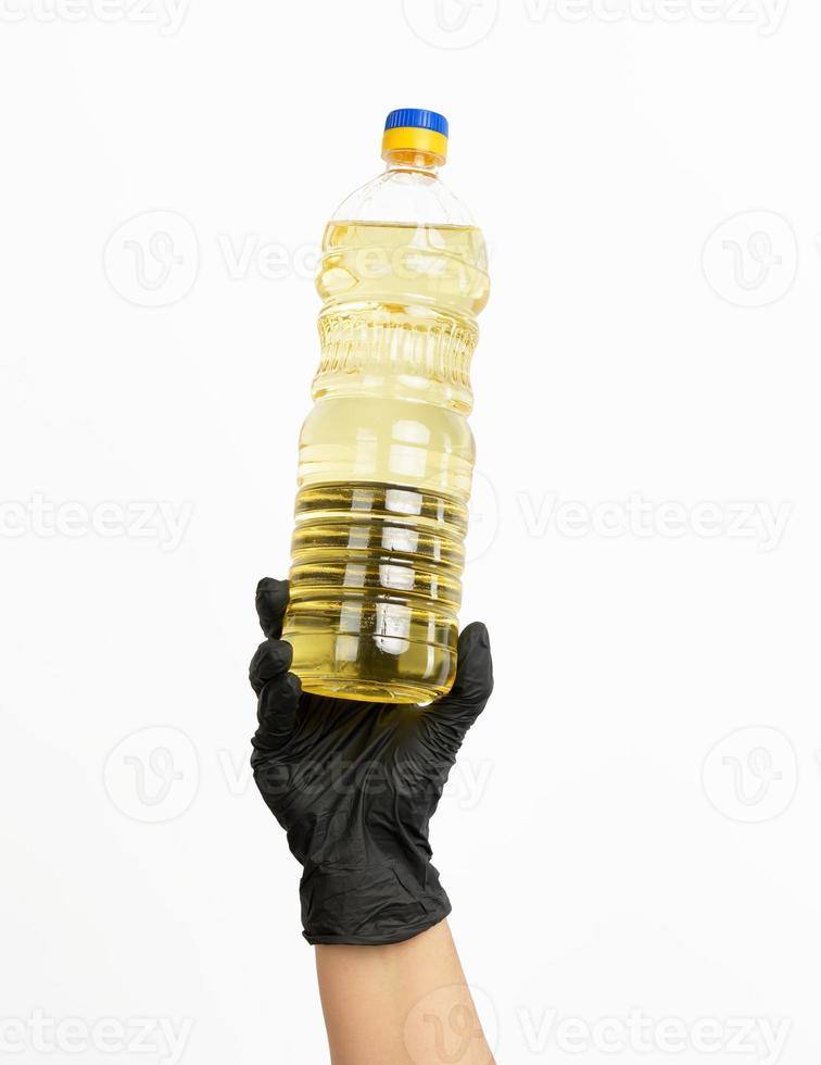 plastic transparent bottle with sunflower oil in hand photo