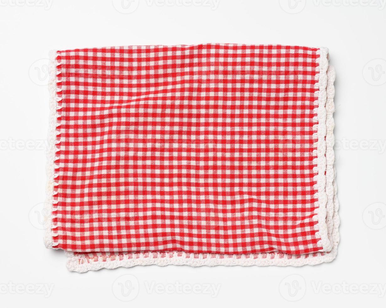 servilleta a cuadros roja y blanca de algodón doblada sobre un fondo blanco foto