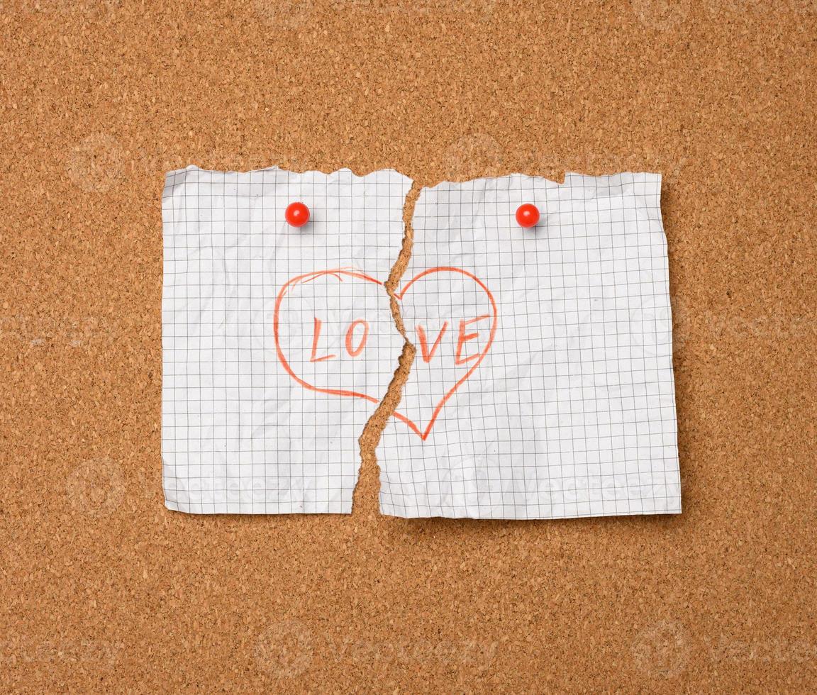 torn white sheet of paper with the inscription love and heart shape photo