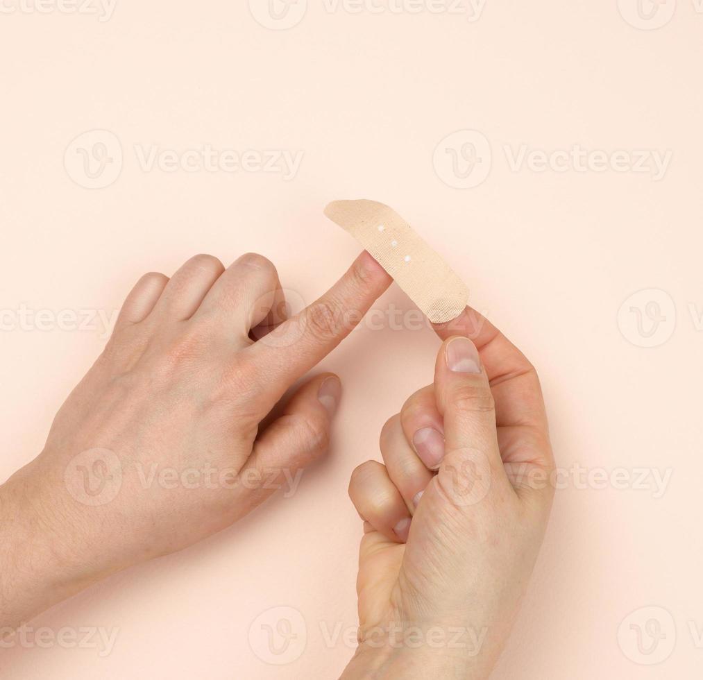 a finger on a woman's hand is sealed with a medical plaster photo