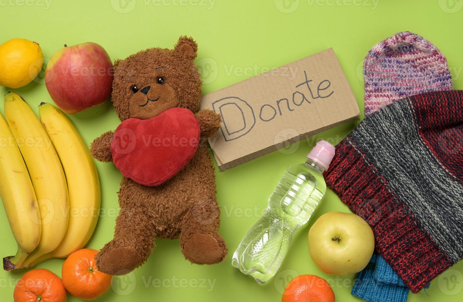 clothes and brown teddy bear on a green background, top view photo