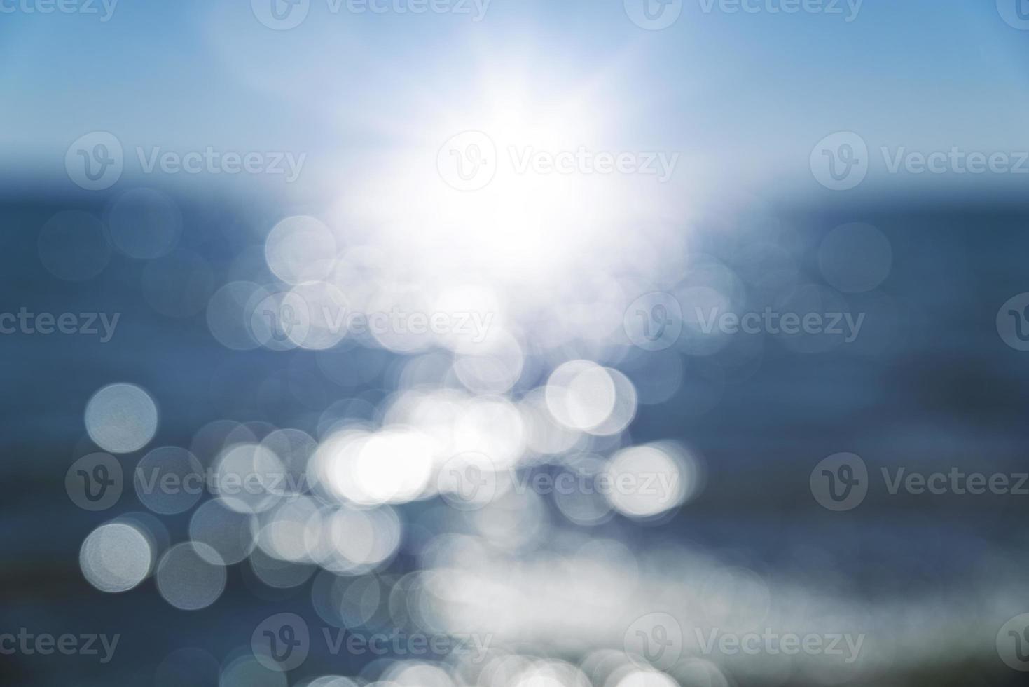 abstract blurred background with a view of the sea and a bright sun and rays photo