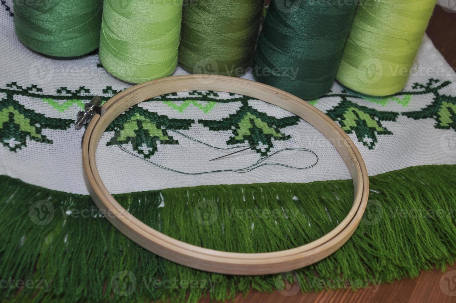 cross-stitch embroidery frame wooden towel in bright green thread photo