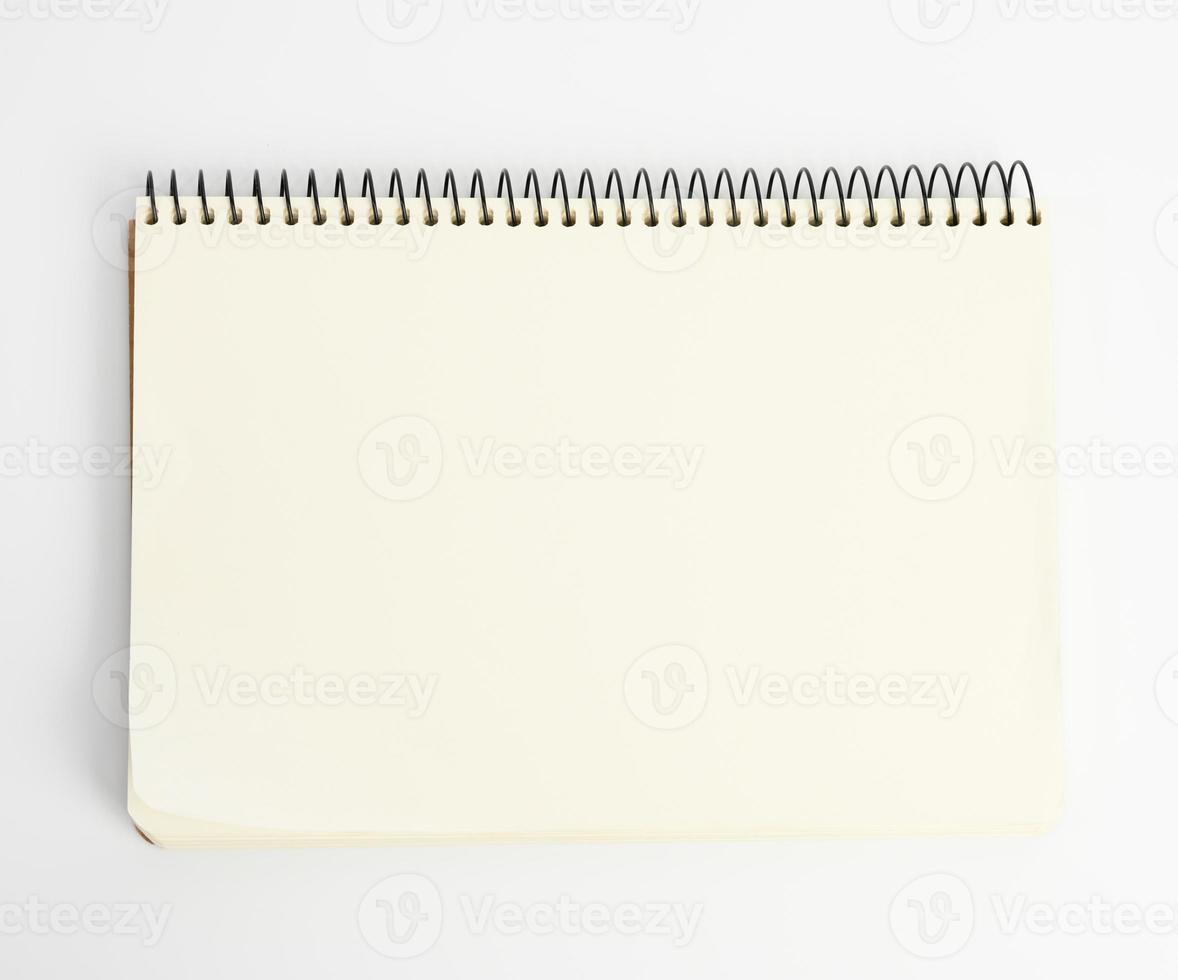 open spiral notepad with blank white sheets on white background photo