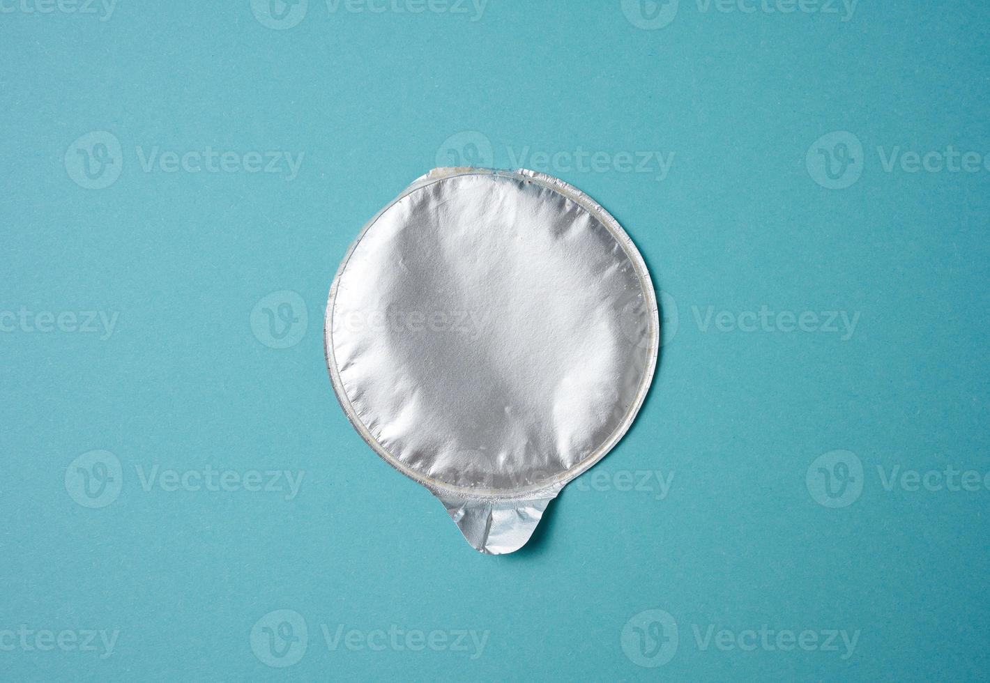 aluminum round lid from under the package with chips on a blue background photo
