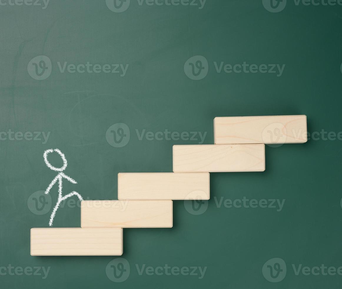 a man drawn in white chalk walks up the wooden steps against the background of a green board. photo