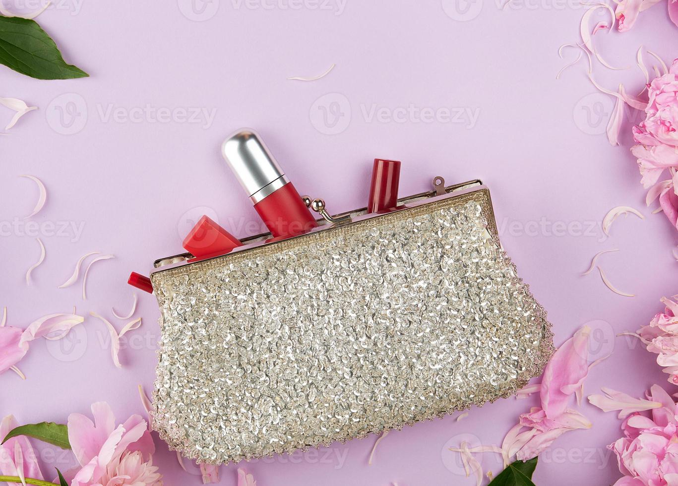 open silver clutch and cosmetics fell out of the middle photo